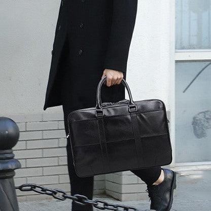 Personne en manteau noir portant une sacoche en cuir noire élégante en plein air